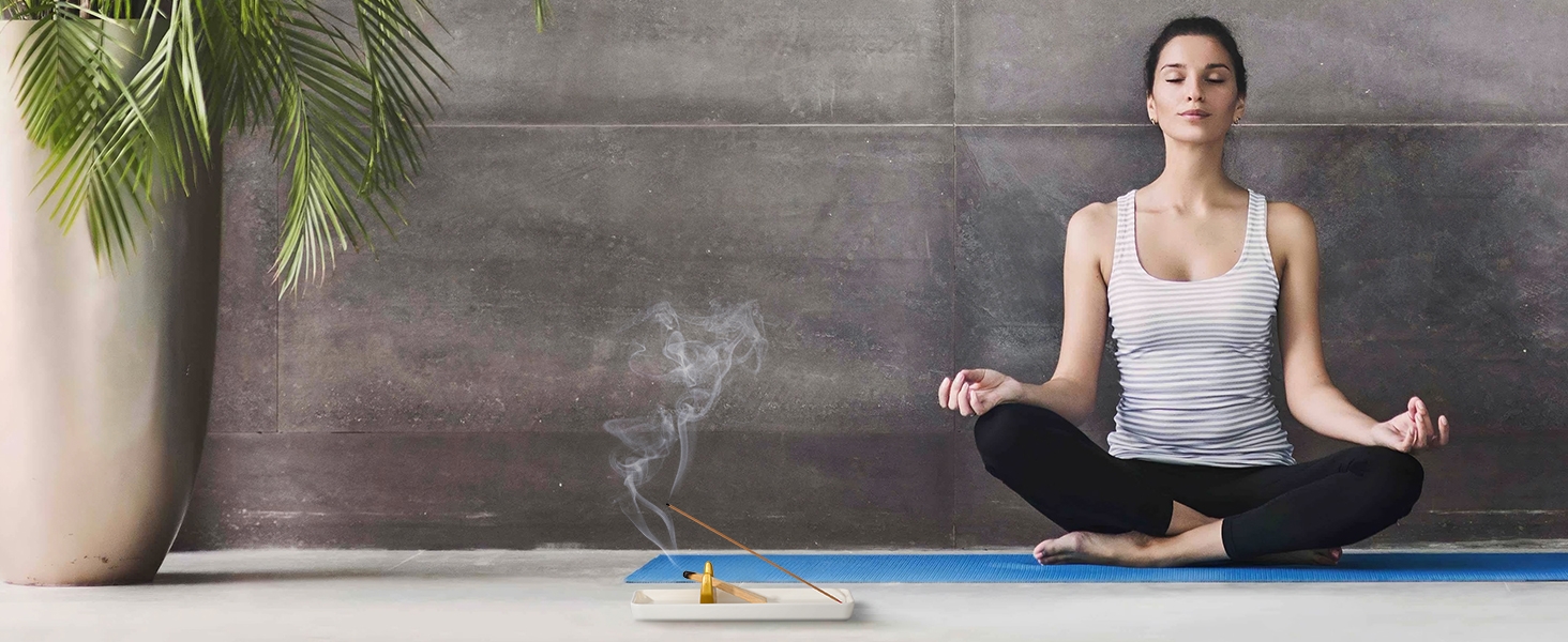 A woman burns sacred wood in a sacred wood rest during meditation.